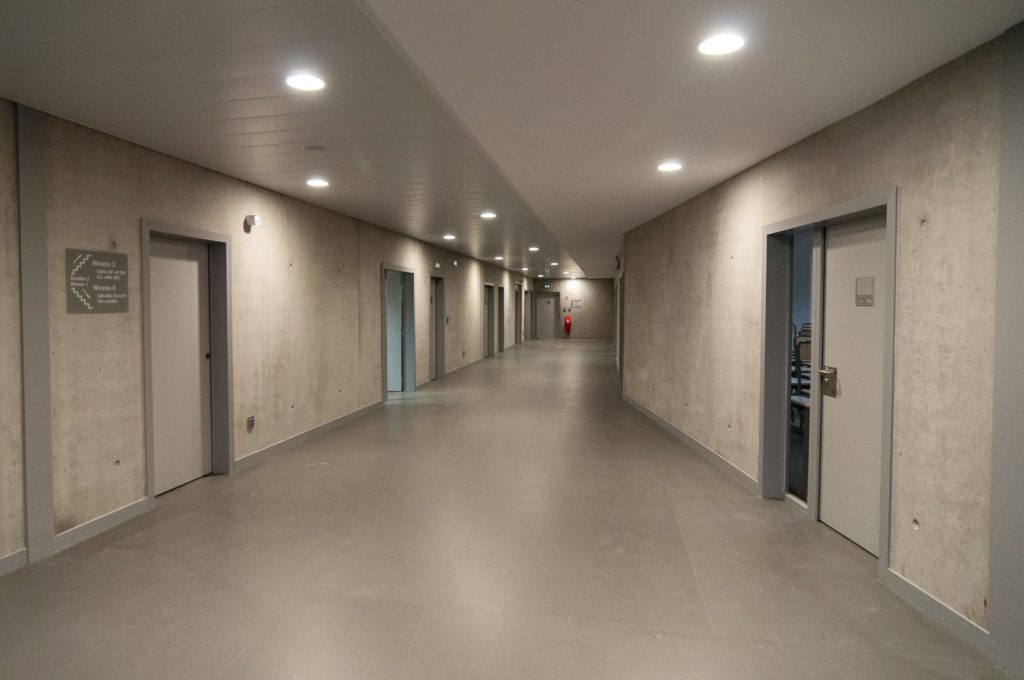 couloir de collège avec des murs en béton brut