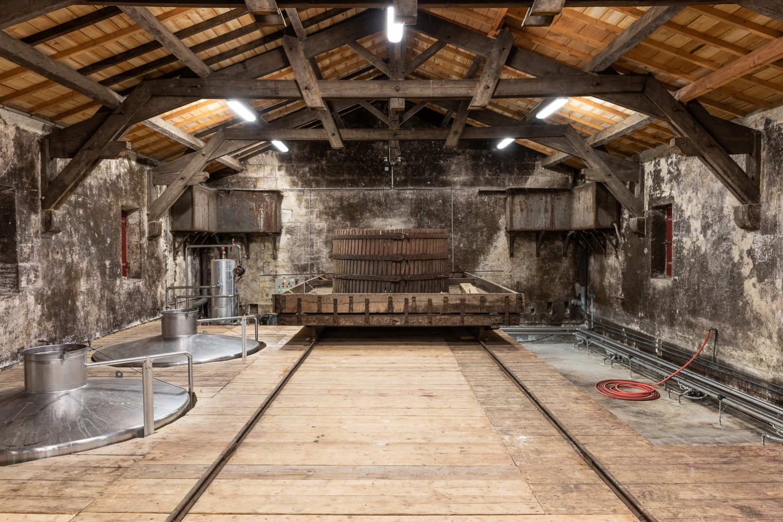 étage du chais avec le pressoir historique et le haut des cuves inox et bétons