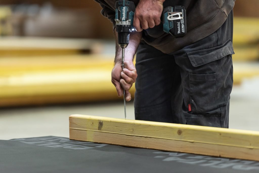 homme qui visse dans un morceau de bois