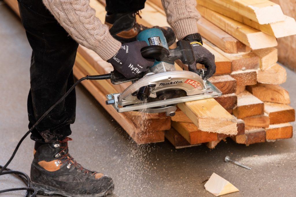charpentier qui coupe un bois à la scie