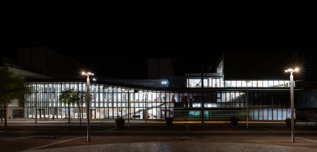 bâtiment avec éclairage de nuit avec un bus