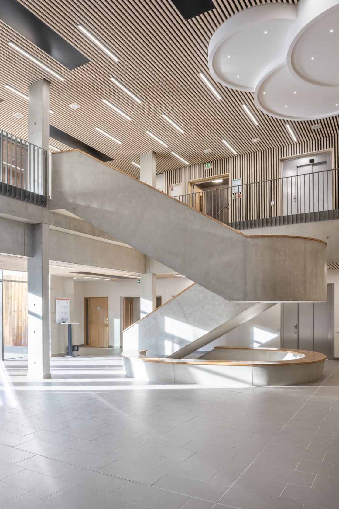hall d'entrée collège avec escalier béton