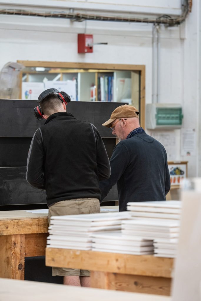 menuisier discutant devant un établi