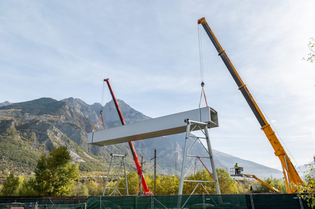 2 grues soulevant une galerie metallique