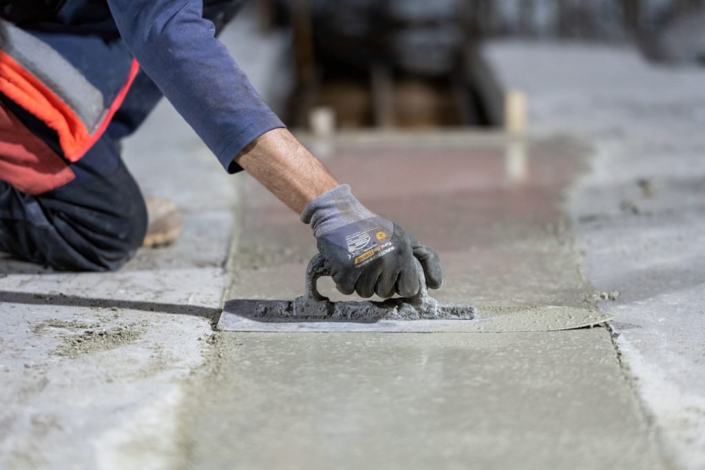 maçon qui lisse du béton