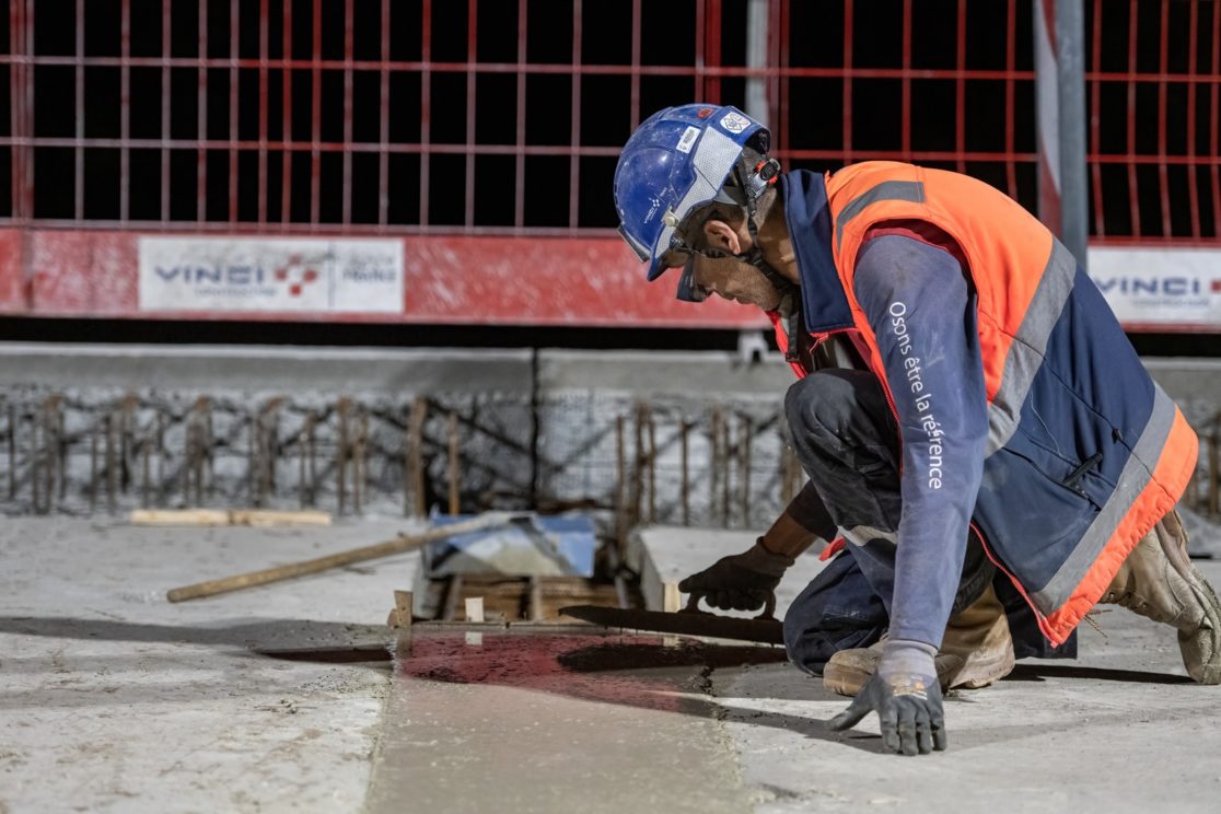 maçon qui lisse du béton