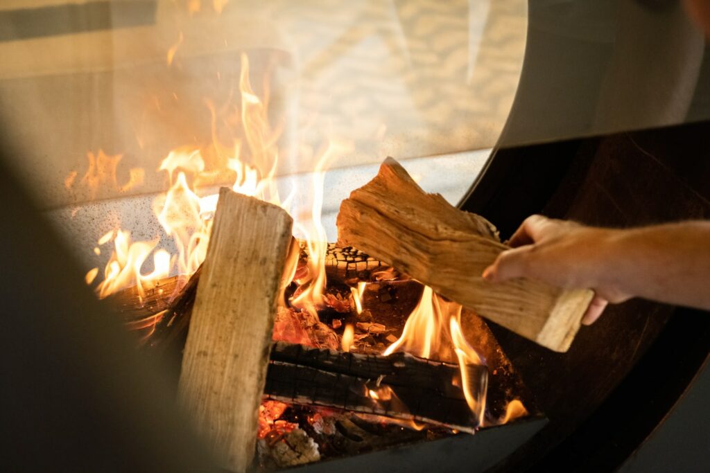 main qui charge le foyer d'une cheminée